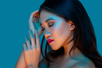 Image showing High Fashion model woman in colorful bright lights posing in studio