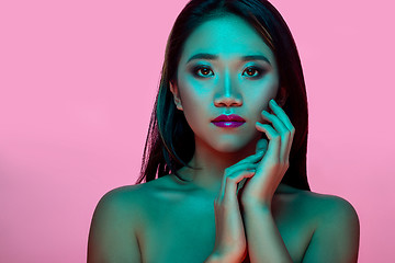 Image showing High Fashion model woman in colorful bright lights posing in studio