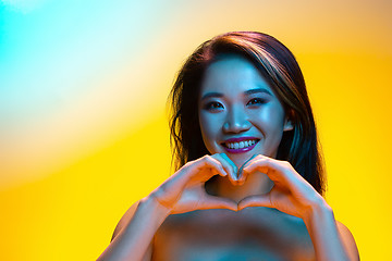 Image showing High Fashion model woman in colorful bright lights posing in studio