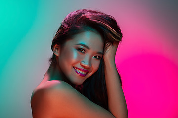 Image showing High Fashion model woman in colorful bright lights posing in studio