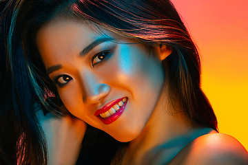 Image showing High Fashion model woman in colorful bright lights posing in studio