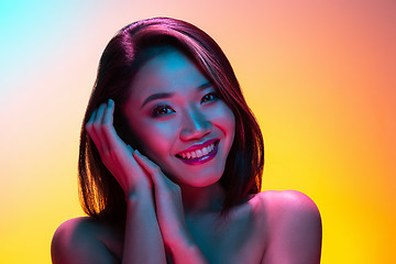 Image showing High Fashion model woman in colorful bright lights posing in studio