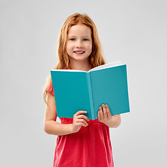 Image showing smiling red haired girl reading book