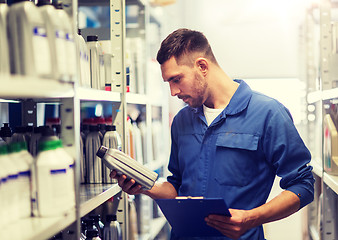 Image showing auto mechanic with clipboard at car workshop