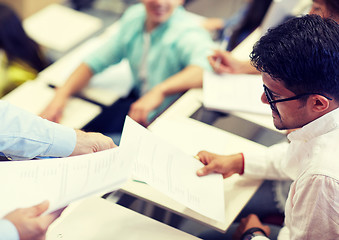 Image showing teacher giving exam test to student man at lecture