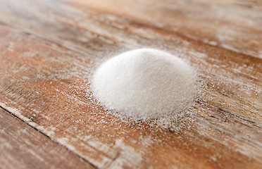 Image showing close up of white sugar heap on wooden table