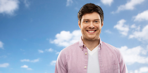 Image showing smiling man over blue sky and clouds background