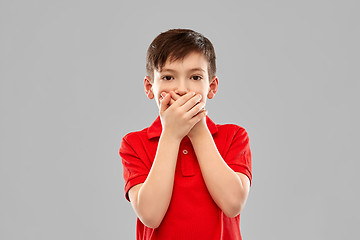 Image showing shocked boy in red t-shirt closing mouth by hands