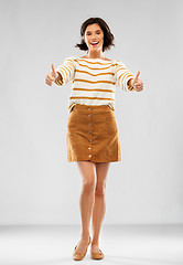 Image showing woman in pullover, skirt and shoes shows thumbs up