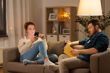 Image showing couple with smartphone and book at home