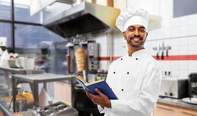 Image showing happy indian chef with cookbook at kebab shop