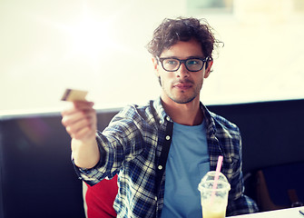 Image showing happy man paying with credit card at cafe