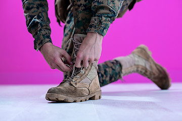 Image showing soldier tying the laces on his boots