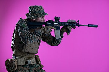 Image showing soldier in action aiming laseer sight optics pink background