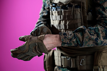 Image showing closeup of soldier hands putting protective battle gloves pink b