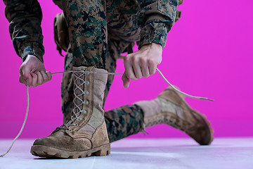 Image showing soldier tying the laces on his boots