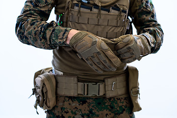 Image showing closeup of soldier hands putting protective battle gloves