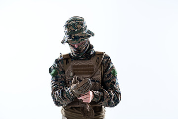 Image showing closeup of soldier hands putting protective battle gloves