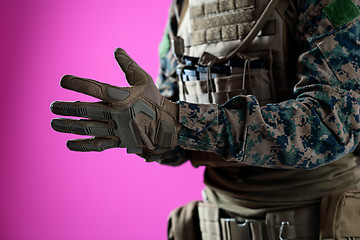 Image showing closeup of soldier hands putting protective battle gloves pink b