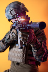 Image showing soldier in action aiming laseer sight optics yellow background