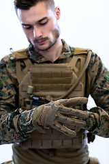 Image showing closeup of soldier hands putting protective battle gloves