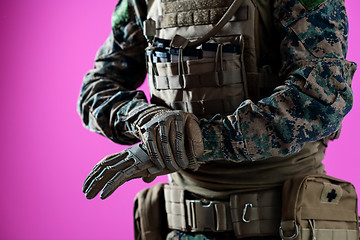 Image showing closeup of soldier hands putting protective battle gloves pink b