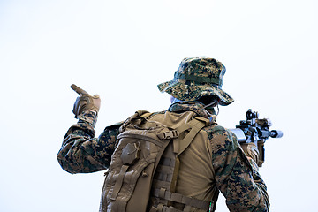 Image showing soldier in action giving comands to team by hand sign