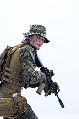 Image showing soldier in action aiming laseer sight optics