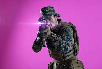 Image showing soldier in action aiming laseer sight optics pink background