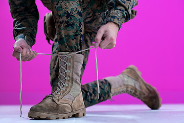 Image showing soldier tying the laces on his boots