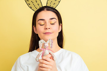 Image showing Easter bunny woman with bright emotions on yellow studio background