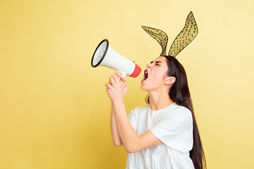 Image showing Easter bunny woman with bright emotions on yellow studio background