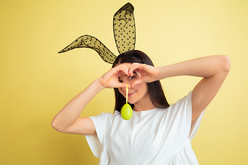 Image showing Easter bunny woman with bright emotions on yellow studio background