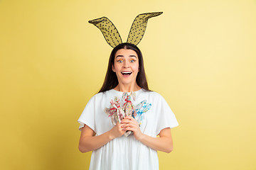 Image showing Easter bunny woman with bright emotions on yellow studio background