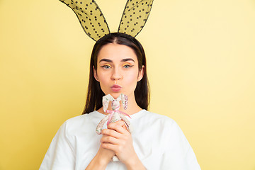 Image showing Easter bunny woman with bright emotions on yellow studio background