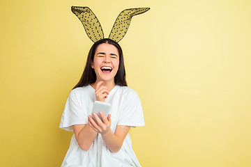 Image showing Easter bunny woman with bright emotions on yellow studio background