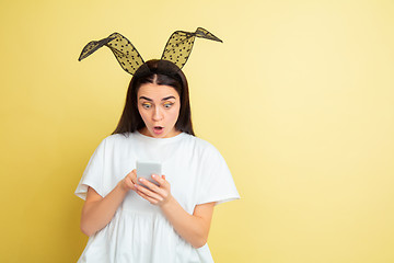 Image showing Easter bunny woman with bright emotions on yellow studio background