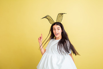 Image showing Easter bunny woman with bright emotions on yellow studio background