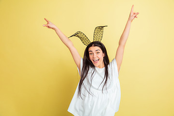 Image showing Easter bunny woman with bright emotions on yellow studio background