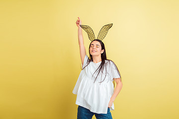 Image showing Easter bunny woman with bright emotions on yellow studio background