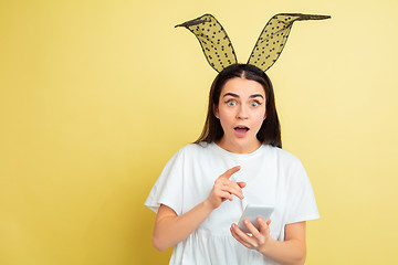 Image showing Easter bunny woman with bright emotions on yellow studio background