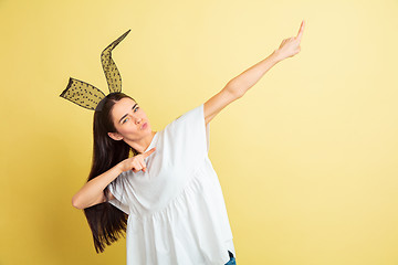 Image showing Easter bunny woman with bright emotions on yellow studio background