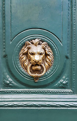 Image showing Doorknocker with head of lion on a green wooden door