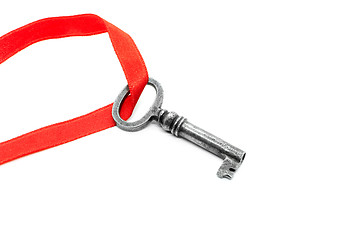 Image showing Vintage silver key with red ribbon on white background