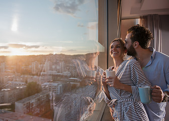 Image showing young couple enjoying evening coffee by the window