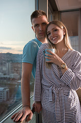 Image showing young couple enjoying evening coffee by the window