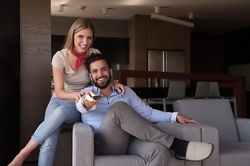 Image showing Young couple on the sofa watching television