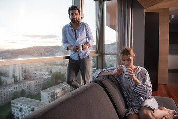 Image showing young couple enjoying evening coffee by the window