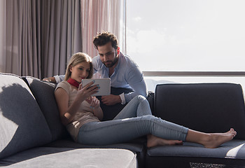 Image showing couple relaxing at  home using tablet computer