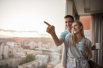 Image showing young couple enjoying evening coffee by the window